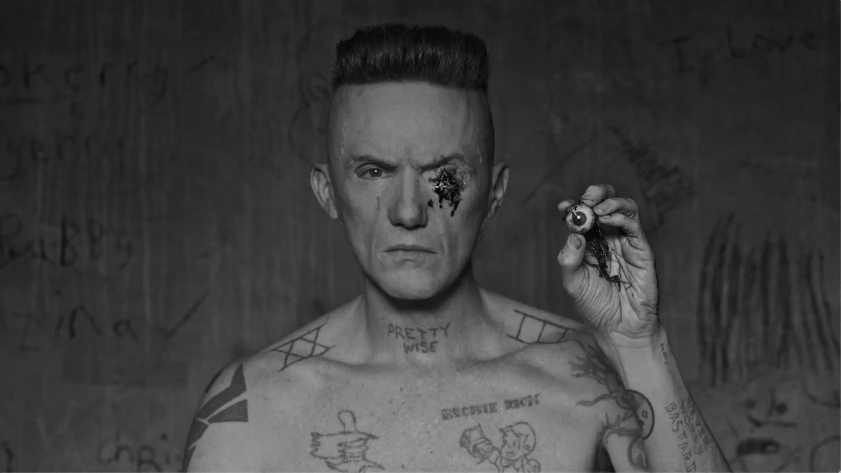 A stark black-and-white portrait with an eye held beside the face.